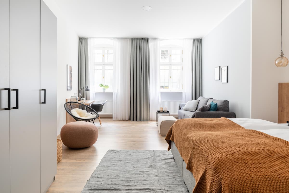 Een moderne slaapkamer met een bed, een bureau en een stoel.
