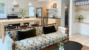 Une cuisine moderne dotée d’un îlot central, de meubles en bois et d’un réfrigérateur encastré.