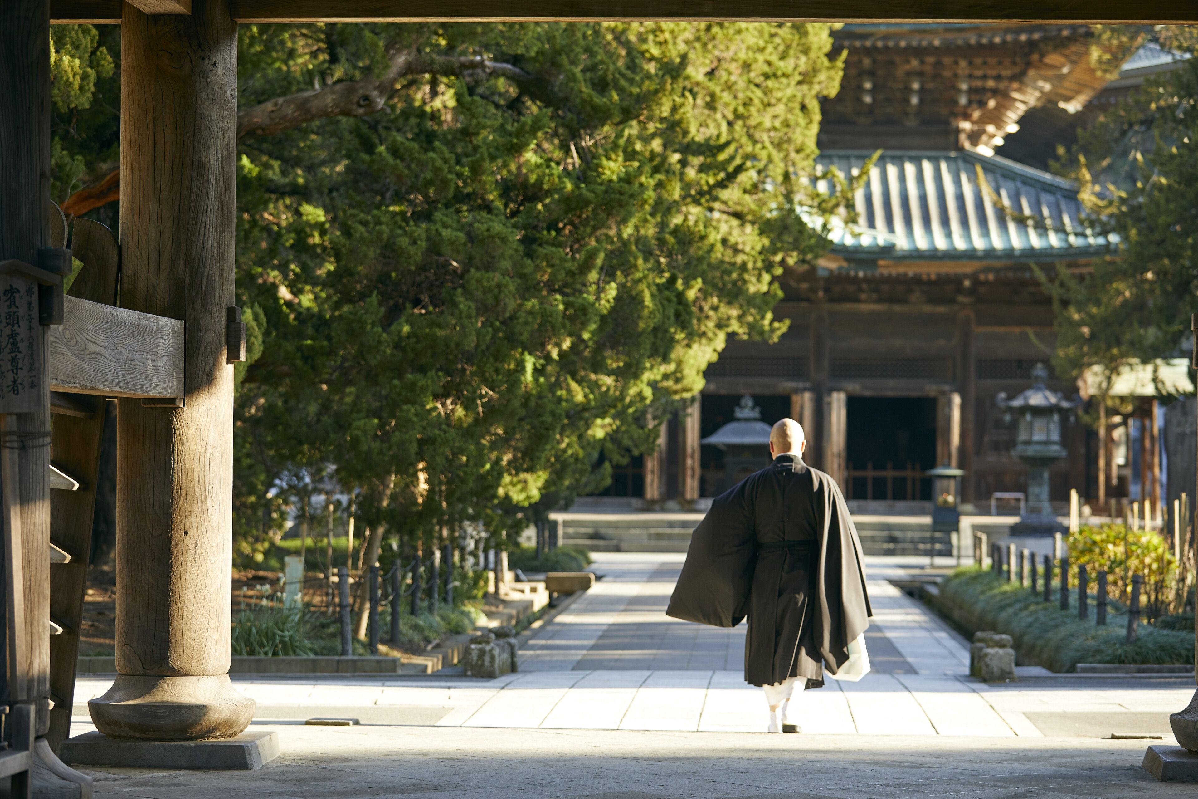 A traditional Japanese building with a tiled roof and wooden pillars.