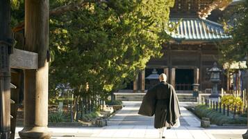 A traditional Japanese building with a tiled roof and wooden pillars.