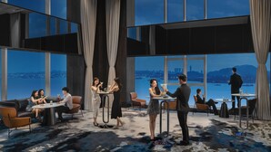 A modern hotel lobby with large windows, a high ceiling, and a view of a cityscape and water. - Crowne Plaza Xiamen Jimei by IHG (Xiamen)