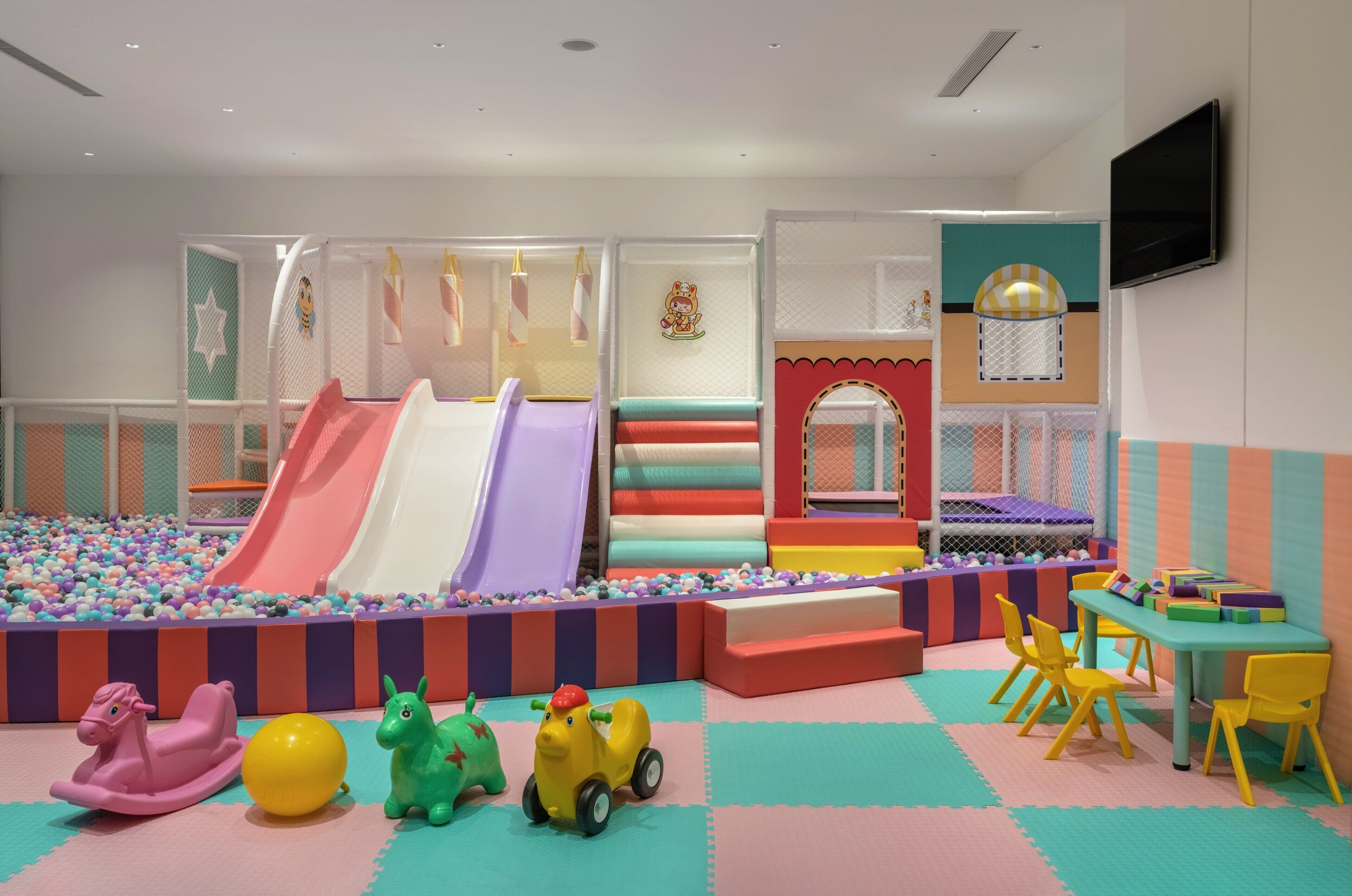 A children's play area with slides, soft play surfaces, and colorful toys.