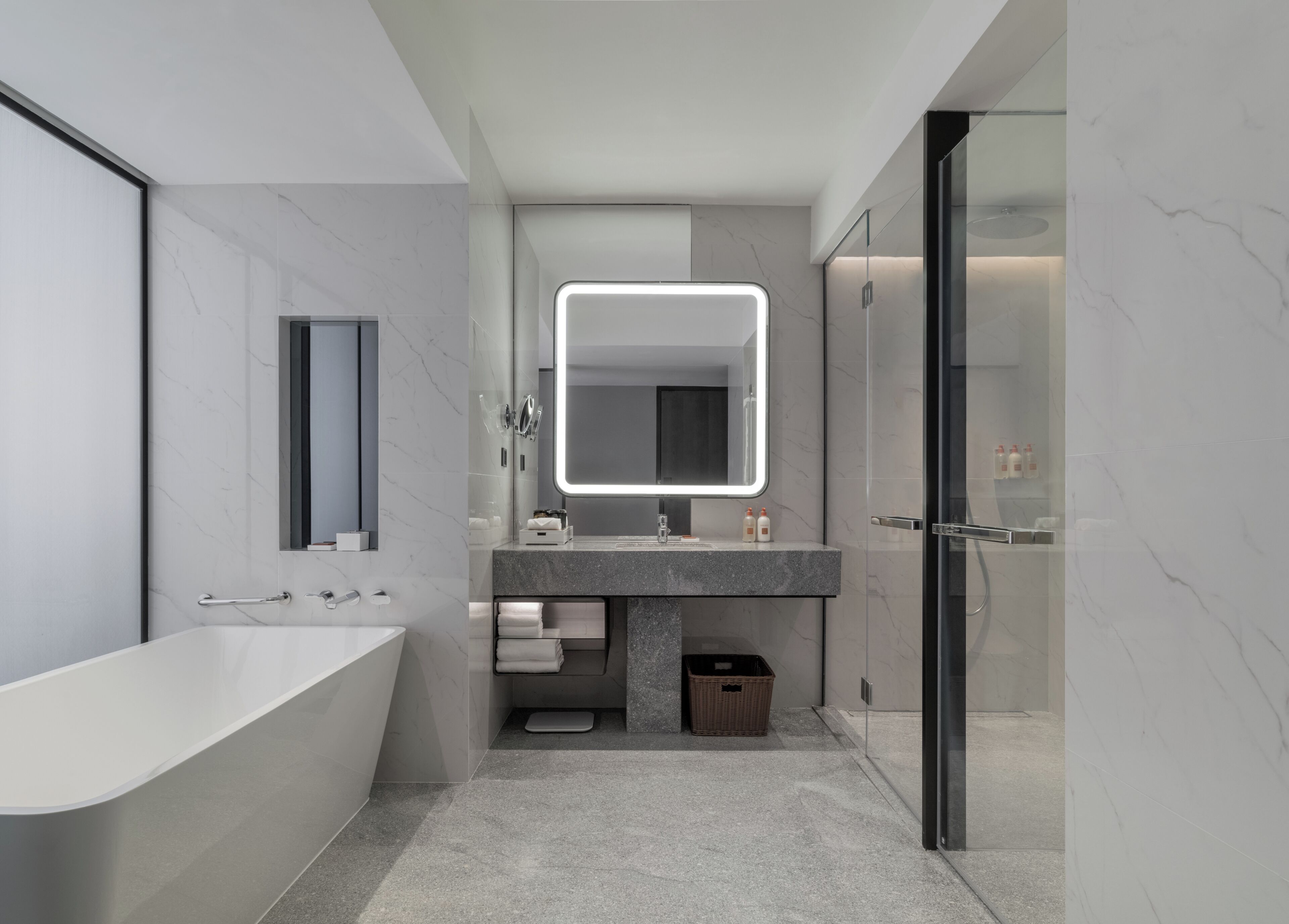 A modern bathroom with a freestanding bathtub, a large mirror, and a glass-enclosed shower.