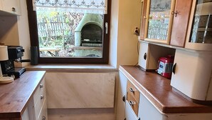 A compact kitchen with a window view, a built-in oven, and a small countertop.