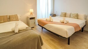 Et hotelværelse med to senge, et natbord med lampe og et vindue med gardiner.