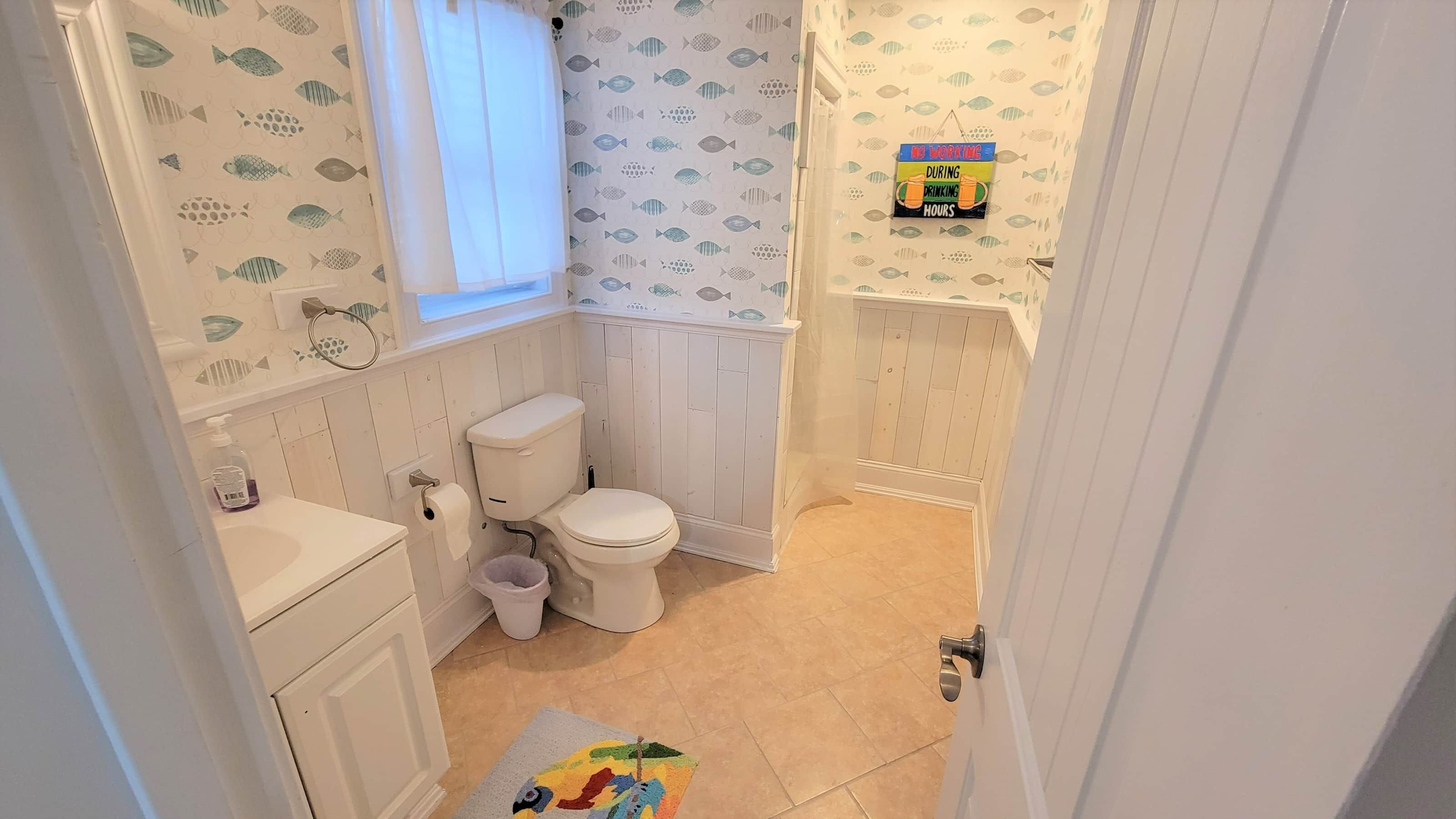 A small bathroom with a toilet, sink, and a window.