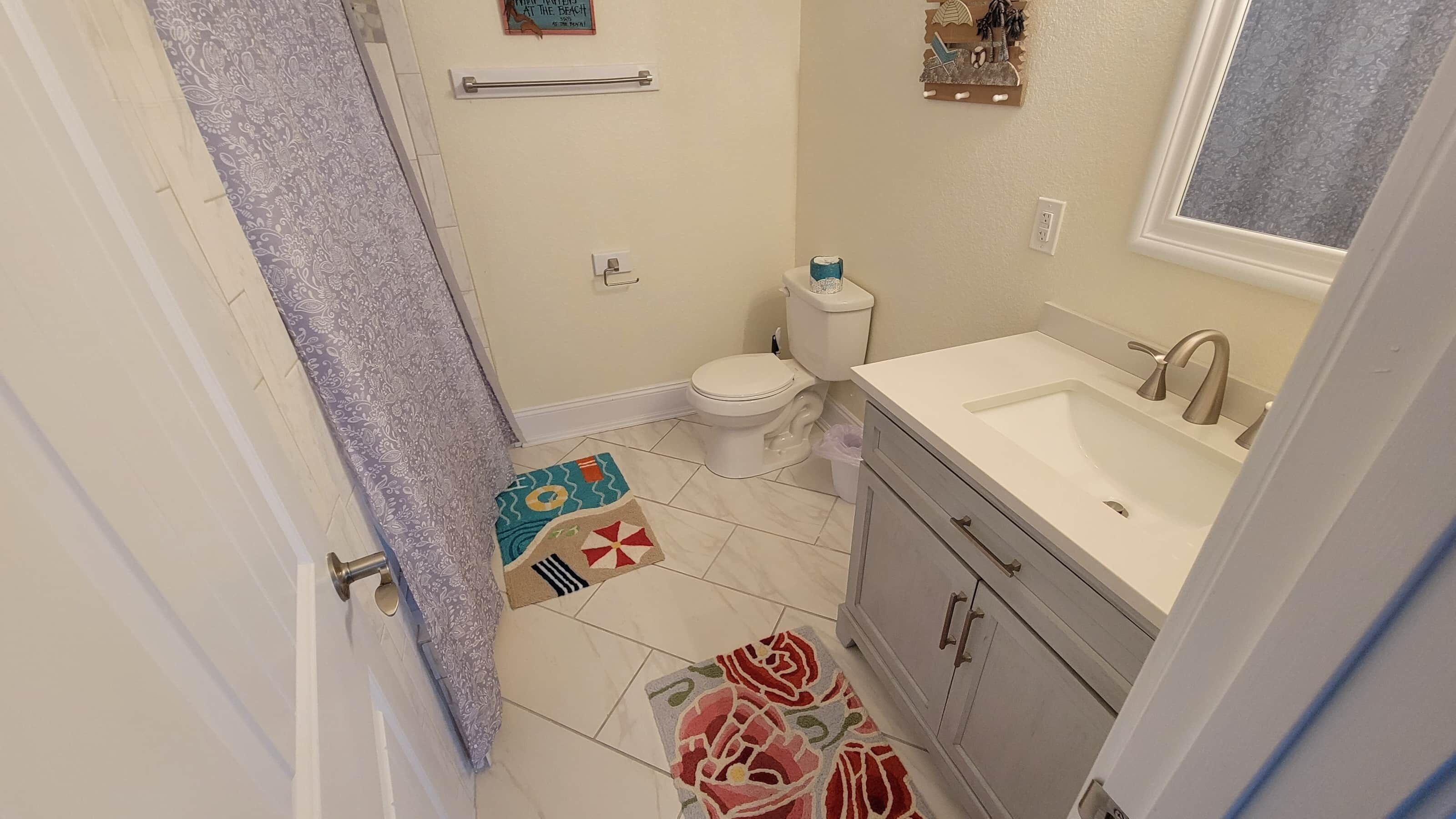 Ein Badezimmer mit Toilette, Waschbecken und Duschbereich.