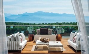 Relax in a serene outdoor space with a breathtaking view of the surrounding landscape and distant mountains.