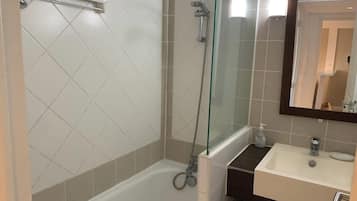 A bathroom with a glass-enclosed shower, a white sink, and a mirror above the sink.