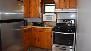 A kitchen with wooden cabinets, a stainless steel refrigerator, a stove, and an oven. - 2 Bedroom Apartment Situated at the Heart of Promised Land State Park (Greentown)