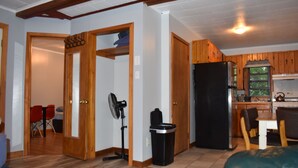 A spacious living area with a wooden floor, a black refrigerator, a dining table with chairs, and a fan. - 2 Bedroom Apartment Situated at the Heart of Promised Land State Park (Greentown)