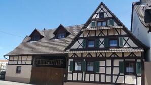 A traditional half-timbered house with a steeply pitched roof, a wooden gate, and a small balcony. - s' Moose Hof (Weisweil)