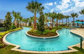 Ein gewundener Pool mit einer Tiefenmarkierung von 3 Fuß, umgeben von Palmen und einer Lounge mit Sonnenschirmen.