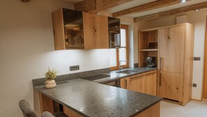 Una cucina con mobili in legno, un piano di lavoro in granito e un forno integrato.
