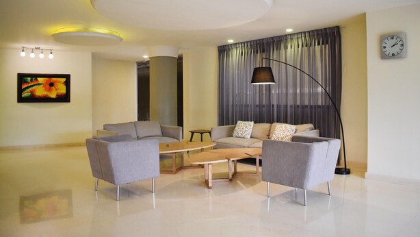 A modern living room with a sofa set, a coffee table, and a floor lamp. - Hotel Caribe 79 (Barranquilla)