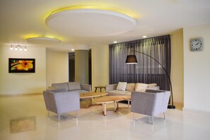 Una sala de estar moderna con un sofá, una mesita de centro y una lámpara de pie.