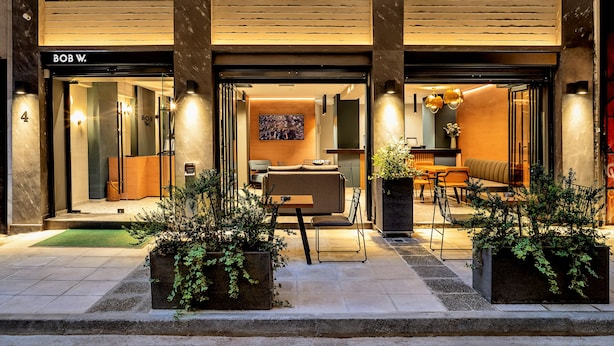 A hotel entrance with a reception desk, seating area, and a large window. - Bob W Athens Akadimia (Athens)