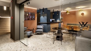 A modern interior with a bar area, seating, and a glass partition. - Bob W Athens Akadimia (Athens)