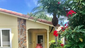 A house with a stone facade, a large red vase in the front yard, and lush greenery. - Beautiful Home with Pool - 3 miles from Siesta Key Beach (Sarasota)