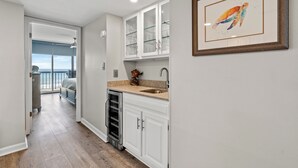 Une cuisine moderne avec des armoires blanches, un comptoir en granit et un évier en acier inoxydable.
