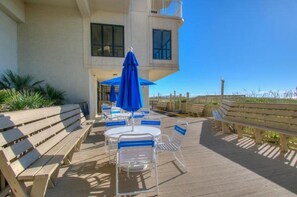 A deck with outdoor seating, including benches and tables, and a view of the ocean. - Windemere 904-3BR/2BA Oceanfront condo in Ocean Drive (North Myrtle Beach)