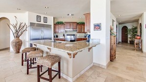 A spacious kitchen with a large island, stainless steel appliances, and wooden cabinets. - Luxury Three Bedroom Ocean Front Condominium (San Felípe)