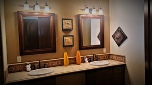 A bathroom with two sinks, a mirror, and wall-mounted lights. - Luxury Three Bedroom Ocean Front Condominium (San Felípe)