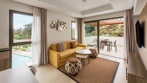 A modern living room with a sofa, coffee table, and ottoman, a pool view, and a balcony with outdoor seating. - Radisson Blu Residences Al Hoceima (Ait Youssef Ou Ali)