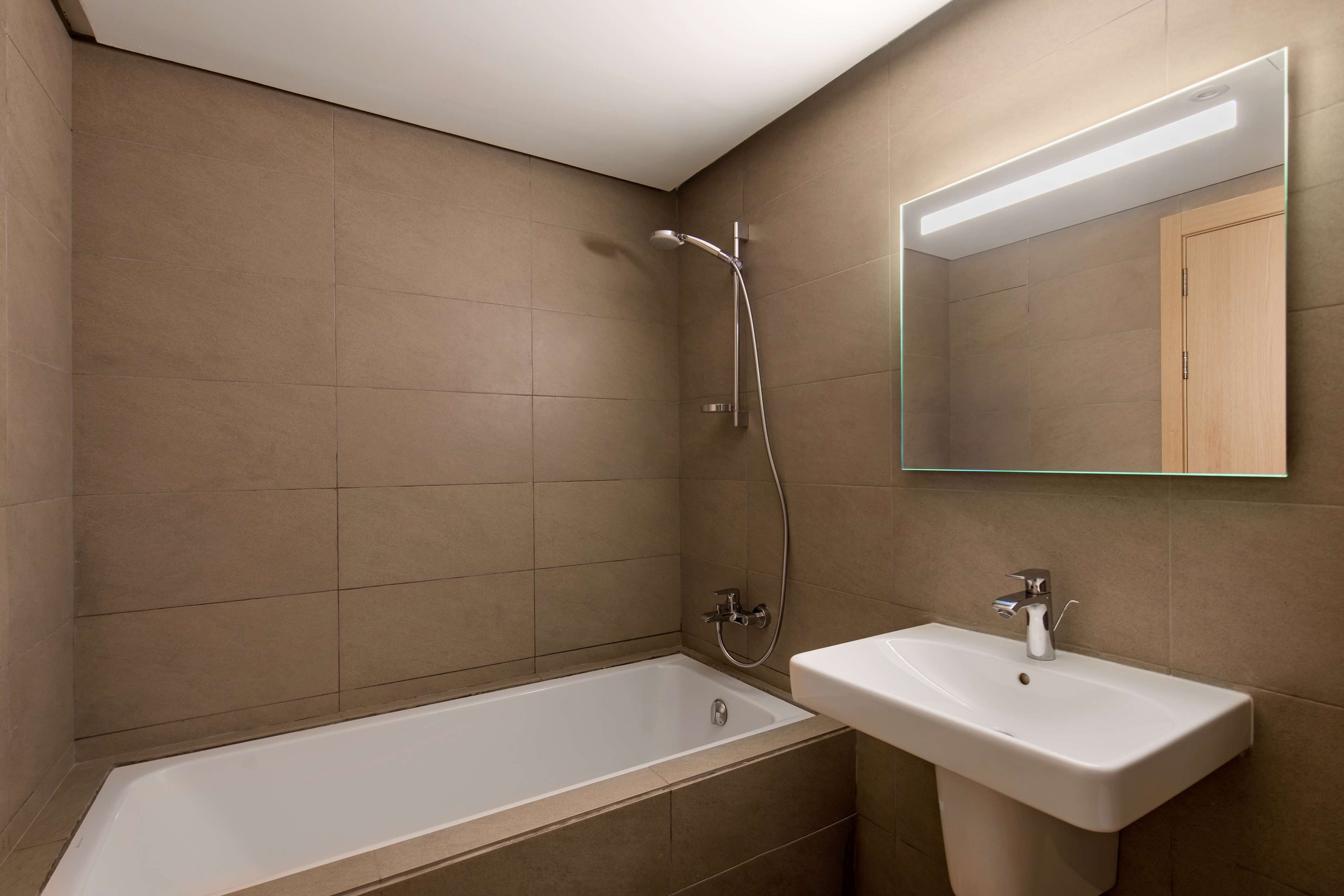 A modern bathroom with a bathtub, a sink, and a shower.