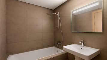 A modern bathroom with a bathtub, a sink, and a shower.