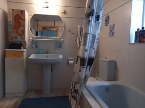 A bathroom with a sink, mirror, towel rack, and a bathtub. - Cosy Villa With Garden, Near the Beach in Greece (Argos-Mykines)