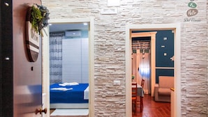A hotel room with a bed, a bathroom, and a dining area with a table and chairs. - Spacious and comfortable apartment in Pompeii, pets allowed (Pompei)