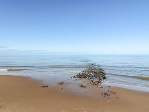 A sandy beach with scattered rocks and footprints. - Flat 3 (Prestatyn)