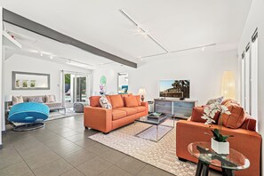 A modern living room with a sofa, coffee table, and a blue bean bag chair.