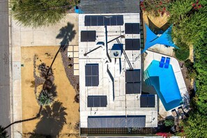 Ein Luftbild eines Wohnhauses mit Solaranlage, Schwimmbad und Terrassenbereich.