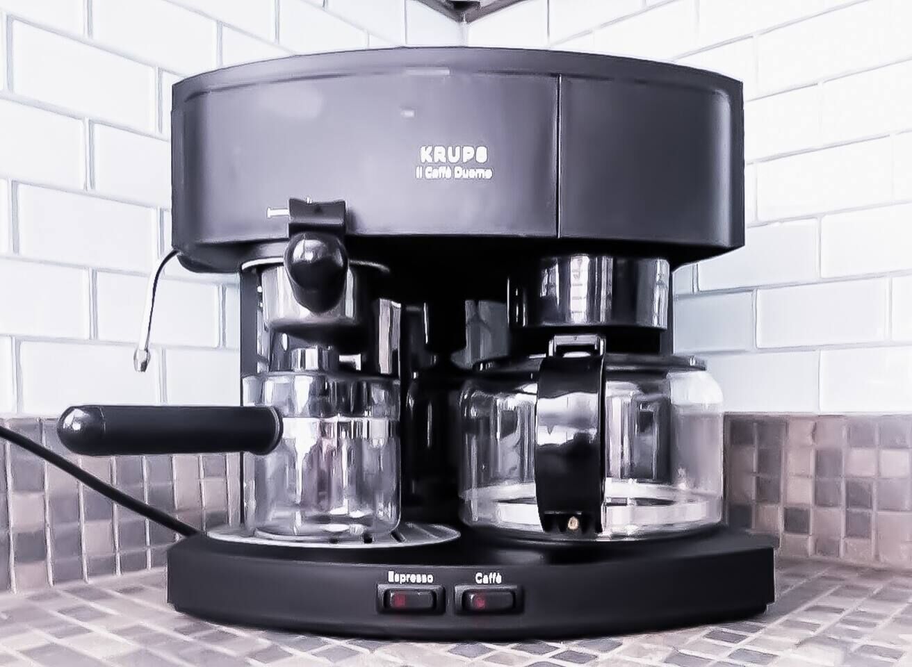 Een KRUPO Il Caffè Duomo espressomachine met twee koffiepotten en knoppen met de tekst 'Espresso' en 'Caffè'.