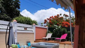 Eine Terrasse im Freien mit mehreren Stühlen und einem Whirlpool.