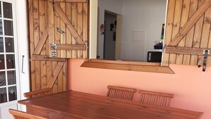 Ein Essbereich mit Holztisch und -stühlen, einem großen Spiegel und Holzwandverkleidungen.