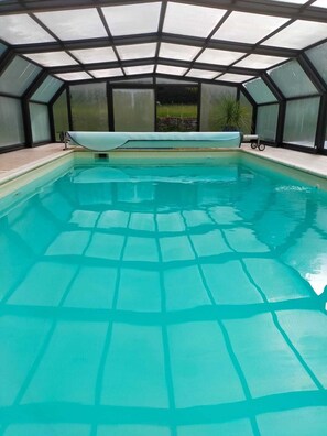 Swimmers can enjoy a serene experience in this rectangular indoor pool surrounded by a unique geometric ceiling.