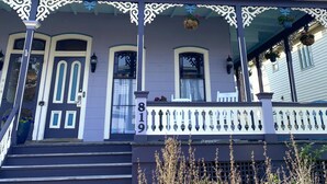 A two-story building with a porch, a mailbox, and a number '819' on the front.