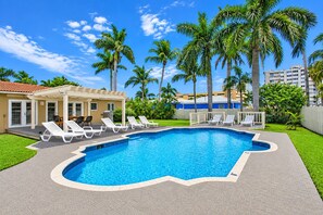 A swimming pool with lounge chairs, a covered patio, and palm trees. - Walk to Beach Luxury 5BR/3BA Villa Hollywood Lakes (Hollywood)