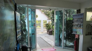 A hotel entrance with glass doors, a fire extinguisher, and a map on the wall. - Pousada Cabore (Paraty)