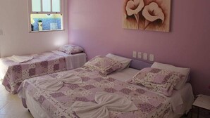 A bedroom with two single beds, a window, and a wall-mounted artwork. - Pousada Cabore (Paraty)
