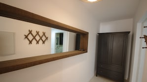 A hallway with a large mirror, a dark wooden wardrobe, and a small decorative wall piece. - 108 - Paraje de Los Lances (Tarifa)