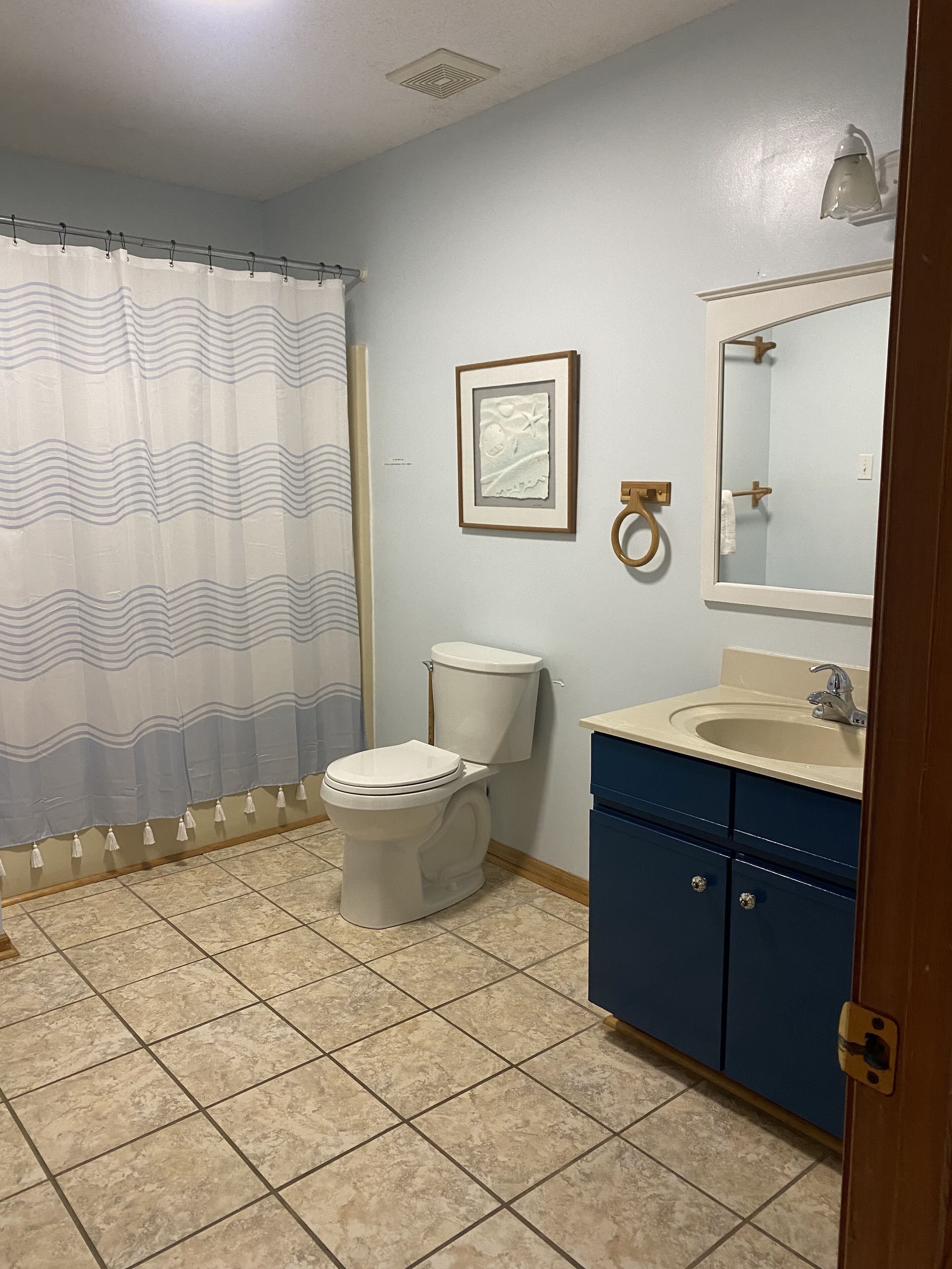 Un baño con inodoro, lavamanos y espejo.