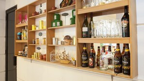 A bar area with shelves stocked with various bottles, glasses, and decorative items. - RedDoorz near Hyperpoint Pasteur 2 (Bandung)