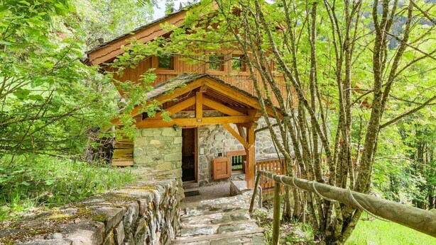 A rustic cabin with a stone foundation, wooden beams, and a porch. - Chalet ski in / out avec vue, emplacement fabuleux (Meribel Les Allues)