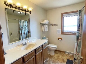 Een bad/douchecombinatie, een haardroger, handdoeken