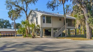 A two-story building with a porch and a staircase leading to a balcony. - Manatee Manor. Waterfront, dock, stilted home. Renovated June '23.  (Homosassa)