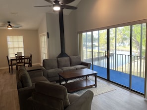 Relax in this inviting living space with a sofa, coffee table, and balcony offering a view of the water and lush surroundings.